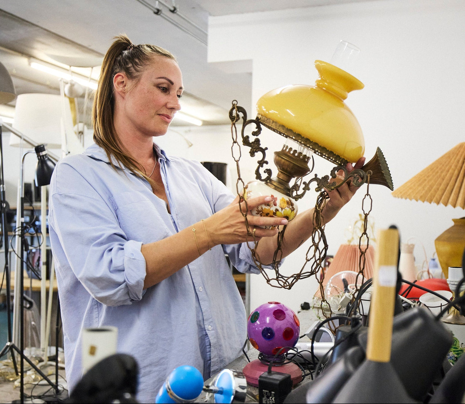 En dame der står med en lampe og kigger på den