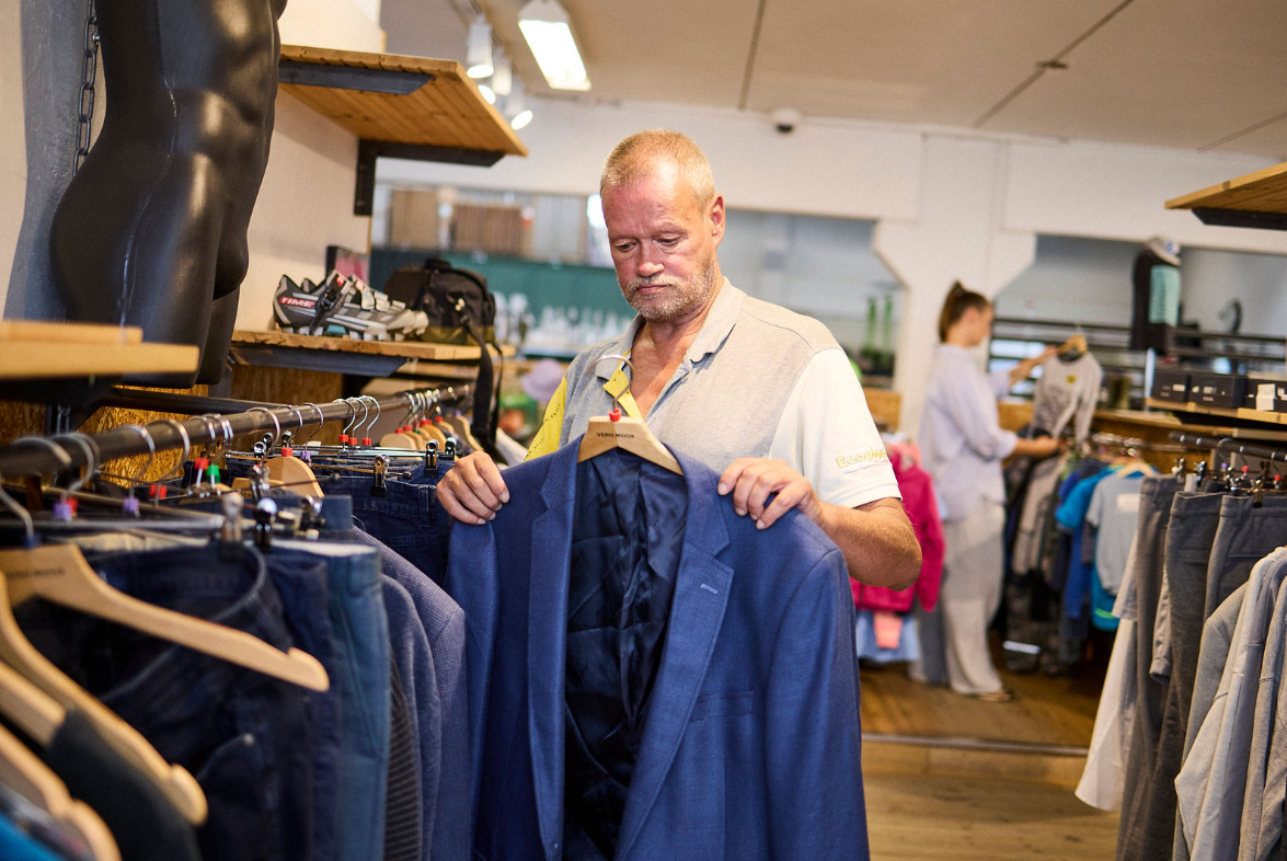 Mand med en jakke på bøjleri hånden